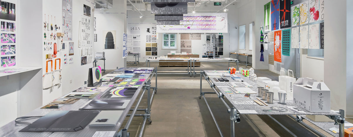 Exhibition displays arranged on tables in a bright gallery interior.